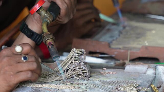 Goldsmith soldering delicate jewelry with blowtorch