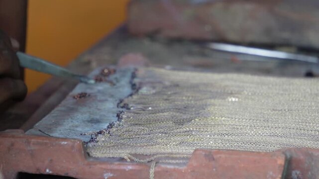 Goldsmith using blowtorch to repair delicate gold chain