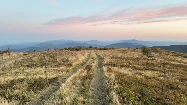 Lonely motorcyclist rides at dawn across Borzhava ridge in Ukraine&rsquo;s Carpathians, heading for a full day of berry picking, scenic rural adventure in autumn mountains