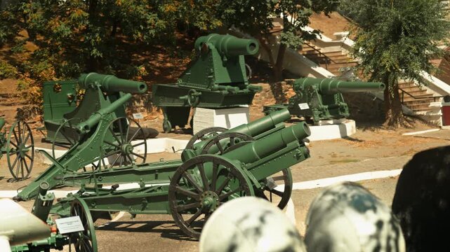 Obsolete, abandoned, and rusty combat guns stand amidst the natural landscape. A graveyard of weaponry. An echo of war.