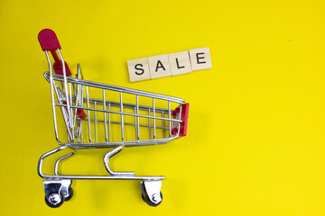 Shopping cart with SALE text, representing limited-time discounts, flash sales, special offers, promotions, supermarket shopping, price reductions, and attractive retail deals for consumers. © bizdof photo