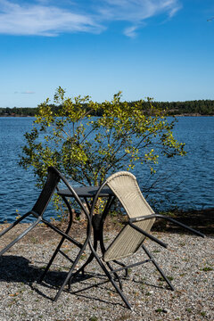 Stockholm, Sweden A picnic table and leaned- in garden chairs on a promontory on the island of Oaxen in the Stockholm archipelago.