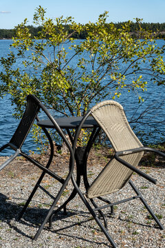 Stockholm, Sweden A picnic table and leaned- in garden chairs on a promontory on the island of Oaxen in the Stockholm archipelago.