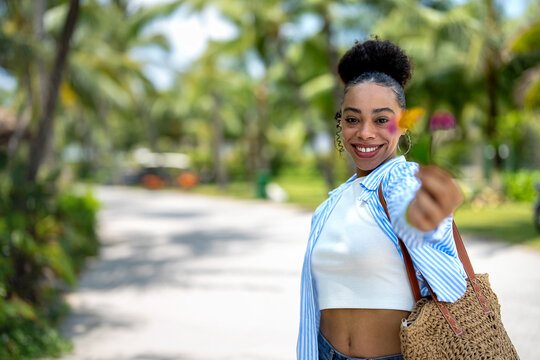 Stylish woman in trendy summer outfit posing in a bright tropical environment on summer vacation