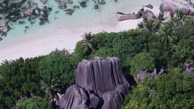 Aerial view of Anse Reunion beach with granite boulders, lush tropical vegetation, and turquoise water in Anse Reunion, La Digue, Seychelles.