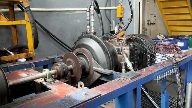 Heavy transmission unit undergoing dynamic testing on hydraulic test bench.