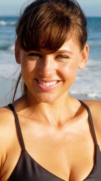 Portrait of an athletic woman at the beach. Vertical video.