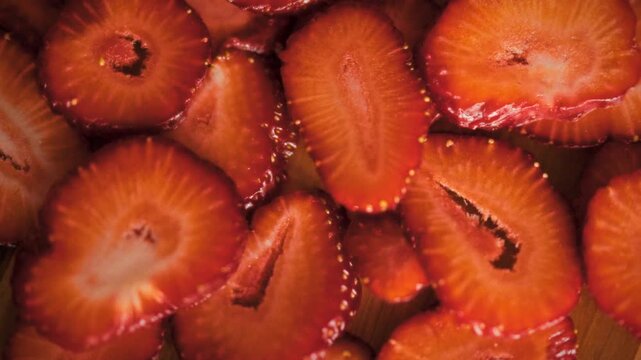 Close-up view of fresh sliced red strawberries displays fruit's texture and structure, with vivid red color and visible juice, presenting the berries in detailed, natural detail for food illustration