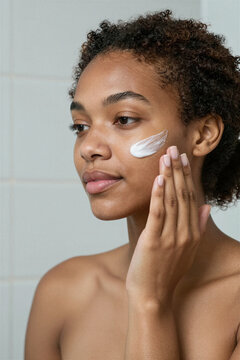 Woman applying moisturiser to her cheek