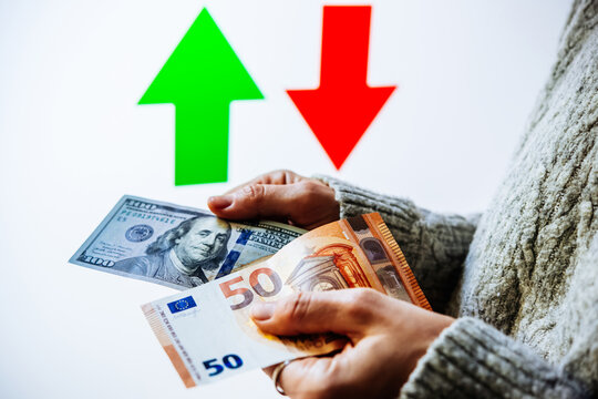 Hands holding U.S. dollars and euros, with contrasting upward and downward arrows.