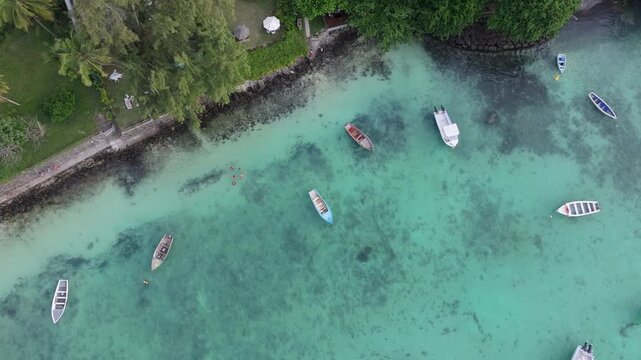 Aerial view of Trou aux Biches Beach with small boats floating in turquoise water along the tropical shoreline in Pamplemousses District, Mauritius.