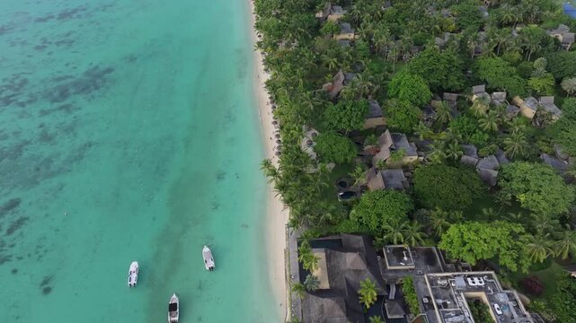 Aerial view of Trou aux Biches Beach with turquoise water, small boats, and lush tropical resort grounds in Pamplemousses District, Mauritius.