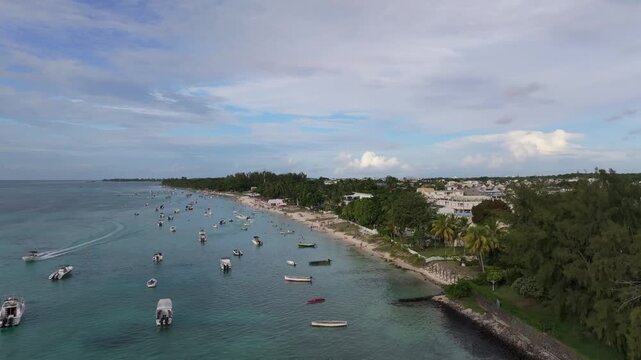 Aerial view of Trou aux Biches Beach featuring numerous small boats floating in clear turquoise water along the coastline Pamplemousses District, Mauritius.