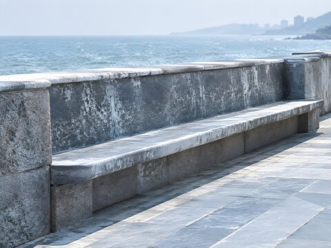 Long concrete and stone bench set into a seaside promenade parapet