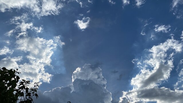 Movement of Beautiful dark rain storm clouds reveals the sun, thunderstorm in dramatic sky, with lens flare. Climate cloudscape scenic. Weather tropical summer squall.