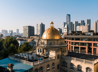 A historic golden-domed building in Wuhan stands in striking contrast to modern towering skyscrapers, beautifully illustrating the city's dynamic evolution from its rich heritage to a vibrant future. © 晨啸 周