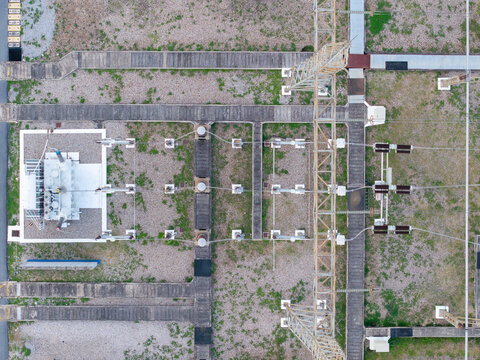 Aerial view of a high-voltage main inlet substation with metal transmission towers, concrete walkways, and gravel ground in Central Seberang Perai, Penang, Malaysia.