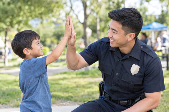 Police officer giving high five to boy at community event