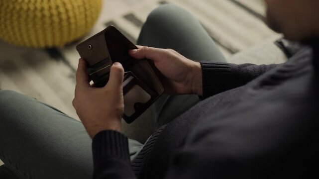 Personal finance and budget management concept, man opening empty leather wallet to check money, close-up shot of financial struggle and economic hardship
