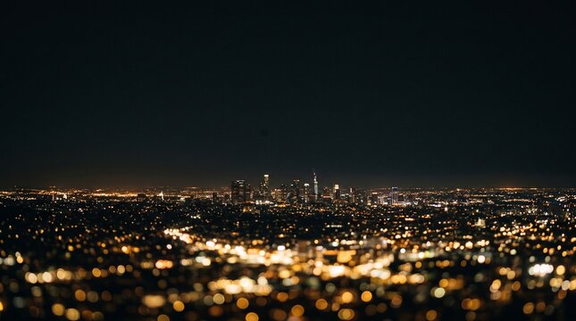 Panoramic nighttime view of a sprawling city illuminated with warm lights and a dark sky