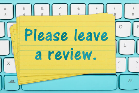 Please leave a Review on a yellow stack of index cards on a computer keyboard