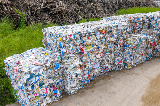 Large stacks of compressed recycled paper bales outdoors