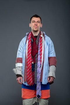 Portrait of a man with a messy haircut standing against a gray wall