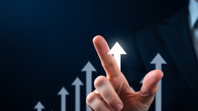 A businessman in a suit pointing at a series of glowing white arrows that are trending upwards on a dark blue background, for business growth
