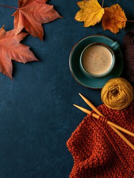 Cozy fall background with knitting supplies and cup of coffee