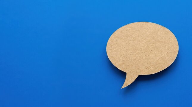 Speech bubble craft paper photo on blue background with copy space