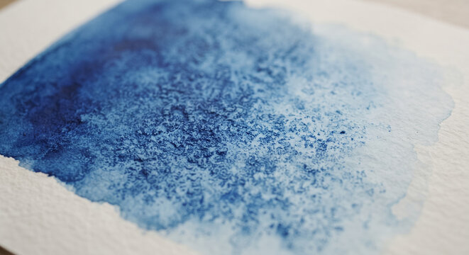 Deep blue watercolor wash with pigment granulation texture on textured paper. Concept of watercolor background, abstract watercolor. Copy space.