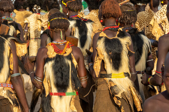 Dassanech women in goat skin capes walking, Omorate, Ethiopia