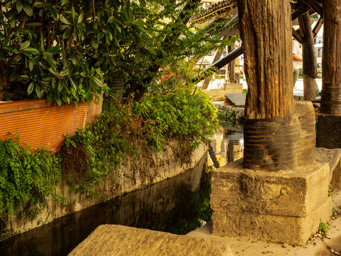 A glimpse of an old washhouse covered by a wooden canopy, where washerwomen once came to do their hard work in every season