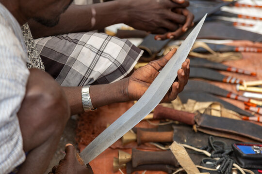 Hands holding a curved knife blade, Artuma, Ethiopia