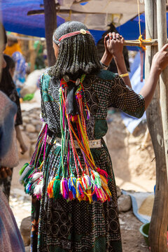 Oromo teenage girl with pompoms, Sambate, Ethiopia