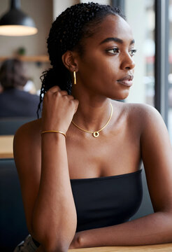 Mindfulness and self reflection, young woman looking out of a window in a cafe with thoughtful expression and gold jewelry for beauty and lifestyle