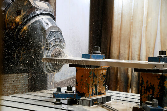 CNC milling machine working with coolant fluid in a modern industrial manufacturing workshop