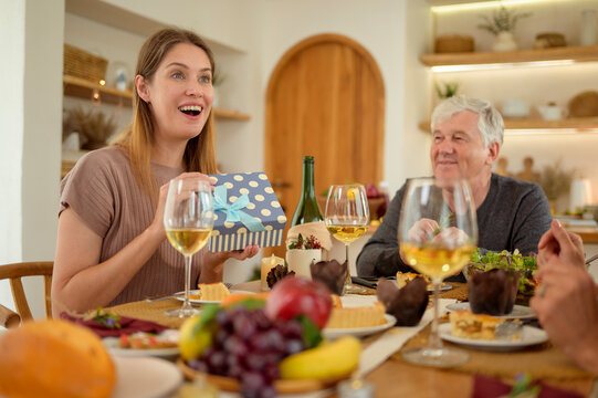 Family Moment of Sharing Gifts During a Dinner Celebration at Home With Loved Ones