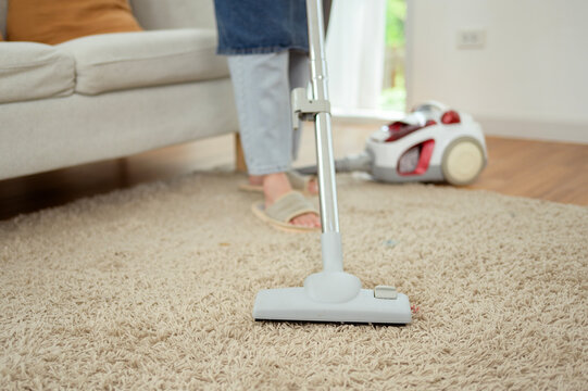 Asian Woman Vacuuming Carpet While Cleaning Bright Modern Home