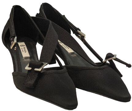 Black canvas pumps with a tapered toe and a strap featuring a metal buckle engraved with the Prada logo. Milan &ndash; Italy, 25 September 2026