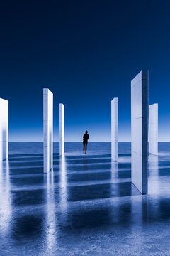 3D standing silhouette among illuminated concrete slabs beneath deep blue open sky