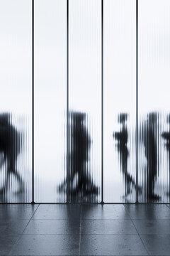3D walking silhouettes behind tall translucent panels in vertical minimalist architecture