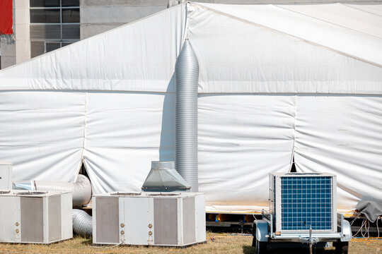 White temporary event tent utilizing multiple outdoor HVAC units for climate control, providing heating or cooling