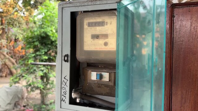 Old Electrical Meter in Outdoor Distribution Box with Open Panel Door