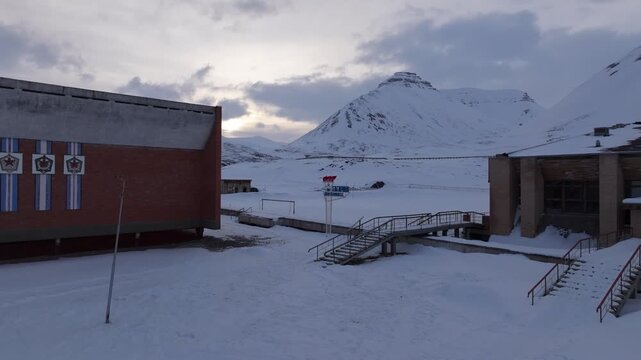 Aerial view of the historic Soviet-era buildings in Pyramiden surrounded by deep snow and mountains in Pyramiden, Svalbard, Svalbard and Jan Mayen.