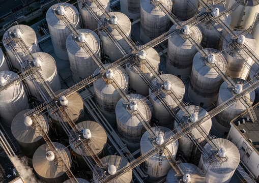 Aerial view of the beer industrial complex featuring rows of large metal storage tanks connected by elevated walkways in Santo Domingo, Dominican Republic.