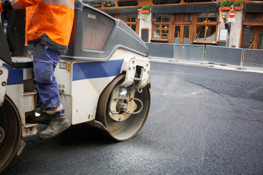 Engine Drives on Fresh Asphalt in Paris Street Near Restaurants