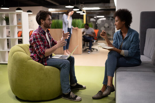 Diverse colleagues discussing project in creative workplace