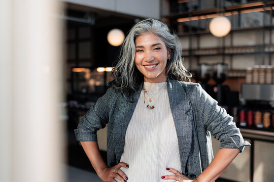 Smiling woman with gray hair in a cafe.