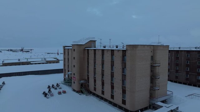Aerial view of Pyramiden, a historic mining settlement with snow-covered buildings and parked snowmobiles in the arctic landscape in Pyramiden, Svalbard, Svalbard and Jan Mayen.